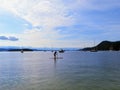 A distant view of a person paddle boarding alone on the open ocean off of galiano island, British Columbia, Canada.