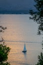 Distant view of a sailboat sailing in the waters of the Mediterranean Sea in Mallorca (Spain) at sunset Royalty Free Stock Photo