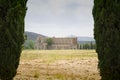 Distant view of san galgano abbey between two cypresses Royalty Free Stock Photo