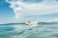 distant view of shirtless male surfer riding on board in ocean at Nusa Dua Beach