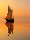 The distinct silhouette of a classic sailing ship stands out against the vibrant, fiery sunset sky, its reflection Royalty Free Stock Photo