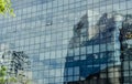 Distorted reflections of urban buildings over a modern glass office building