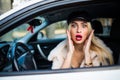 Distracted fright face of a woman driving car, wide open mouth eyes holding wheel side window view. Negative human face expression Royalty Free Stock Photo