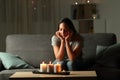 Distracted woman looking at candles light during blackout