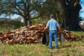 A distraught man with a rake and garbage bag in his hands is standing in front of a giant pile of leaves Royalty Free Stock Photo