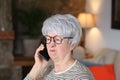 Distraught senior woman calling from home