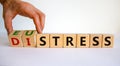 Distress or eustress symbol. Male hand turns cubes and changes the word `distress` to `eustress`. Beautiful white background,