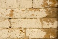 Distressed beige paint on tan brick wall