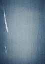 Distressed blue denim fabric with vertical tear marks on the left. Royalty Free Stock Photo