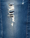 Distressed Blue Denim Jeans with Ripped Hole Showing White Threads Close Up Royalty Free Stock Photo