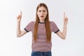 Distressed confused serious-looking caucasian woman in striped t-shirt, frowning puzzled and disappointed, squinting