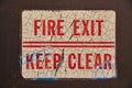 Distressed Fire Exit Sign on Dark Wall - Vintage Safety Neglect