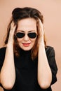 Distressed middle aged woman in sunglasses covering her ears from loud noise Royalty Free Stock Photo