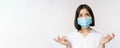 Distressed and miserable young asian woman in face mask, looking up, looking up sad, standing over white background