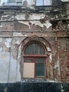 Distressed Old Wall With Exposed Bricks, Peeling Paint And An Arched Window