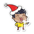 distressed sticker cartoon of a man laughing wearing santa hat