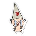 distressed sticker of a crying pig wearing dunce hat