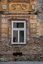 The distressed surface of the old buildingÃ¢â¬â¢s exterior with an antique window Royalty Free Stock Photo