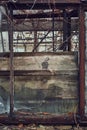 Distressed window of the abandoned ruined greenhouse