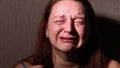 Distressed woman hysterically cry and speak in dark closeup. Tears roll down cheeks. Splash out emotions, weep bitterly.