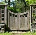 Distressed Wood Gate with Stacked Stone, Grass and Trees.