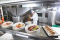 The distribution table in the kitchen of the restaurant. the chef prepares a meal on the background of the finished Royalty Free Stock Photo