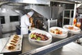 The distribution table in the kitchen of the restaurant. the chef prepares a meal on the background of the finished Royalty Free Stock Photo