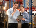 Distribution warehouse manager and client businesswoman using digital tablet checking inventory storage on shelf. Storehouse Royalty Free Stock Photo