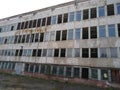 Distroyed industrial building with broken windows. Grey Royalty Free Stock Photo