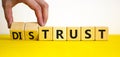 Distrust or trust symbol. Businessman turns wooden cubes, changes words `distrust` to `trust`. Beautiful yellow table, white Royalty Free Stock Photo