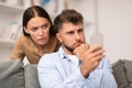 Distrustful young woman sneakily checks her boyfriend's phone at home Royalty Free Stock Photo