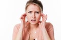 Disturbed young blond woman sulking, plugging her ears against stress Royalty Free Stock Photo