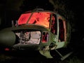 Disused abandoned Helicopter grounded at night with red internal lighting to show hand silhouette, nose body and