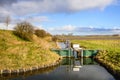 Ditch with a small weir in a Dutch polder area Royalty Free Stock Photo