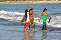 DIU, INDIA - JANUARY 6, 2014: Colorful and beautiful young women walking on the seashore in Diu Island Royalty Free Stock Photo