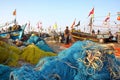 DIU, INDIA - JANUARY 9, 2014: Fisherman working on his net at Vanakbara Fishing port with colorful fishing nets in the foreground