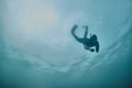 Diver ascending towards light in blue water Royalty Free Stock Photo