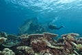 Diver exploring underwater shipwreck.