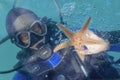 Diver holds starfish