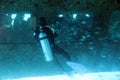 Diver in mask flippers and with oxygen balloons diving in sea water