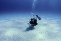 Diver over white sand