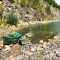 Abandoned boat in flooded quarry with blue crystal water.