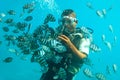 Diver swimming under water and feeding exotic fishes