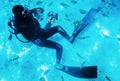 Diver swimming underwater with coral reefs