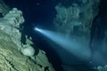 divers flashlight beam illuminating a caves features