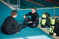 Divers in scuba gear leisures after dive lesson