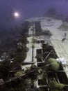 A divers torch near the wing of the World War II Japanese Emily Flying Boat wreck in Truk