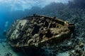 divers visiting an underwater wreck of a metal sailboat