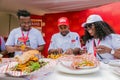 Diverse African judges tasing and scoring meals at cooking competition