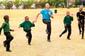 Diverse African Primary School children doing physical exercise PT lesson